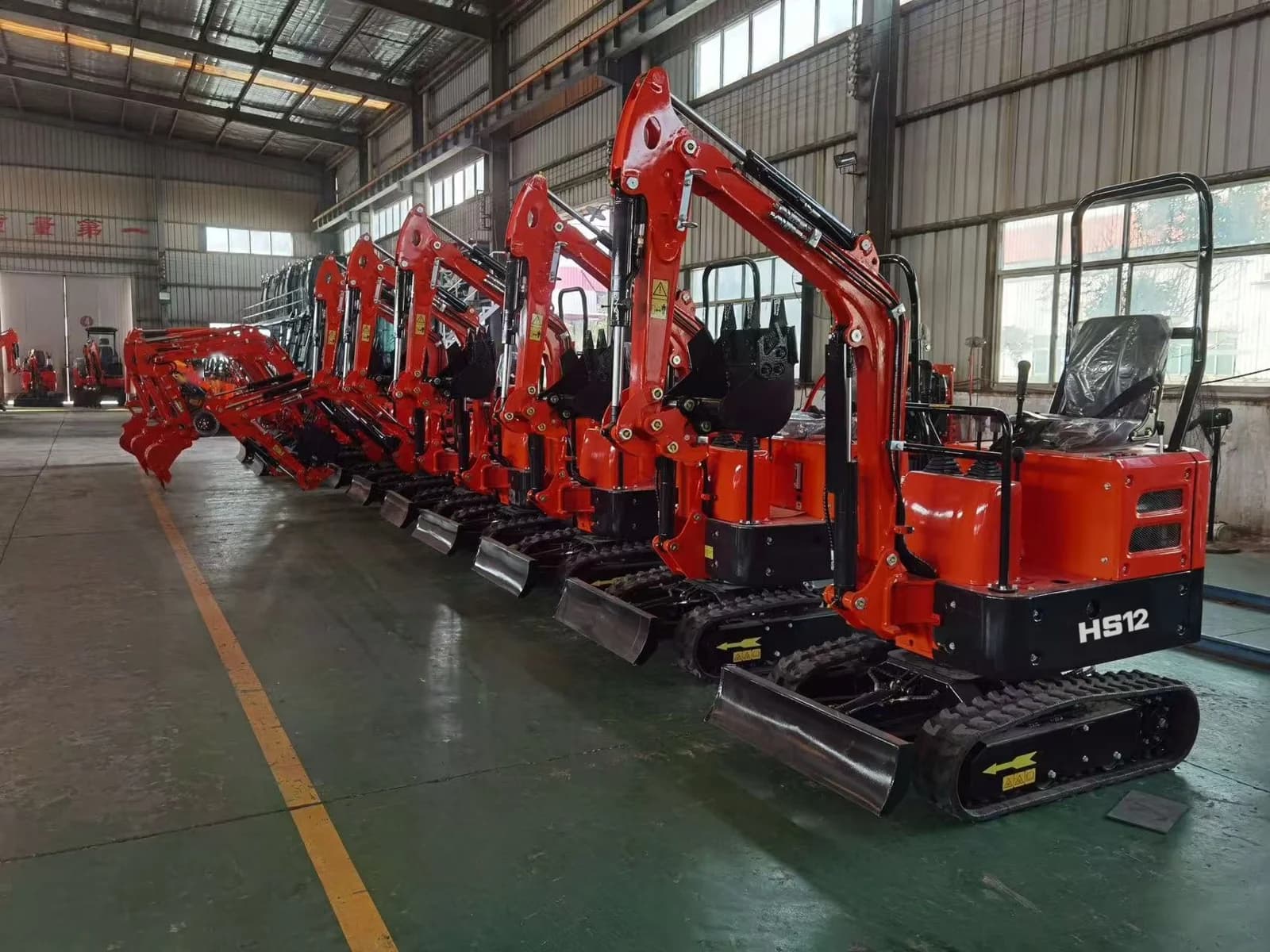 Completed red HERESTRONG HS12 mini excavators in the workshop